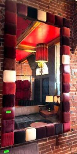 DESCRIPTION 90" X 52" WALL MIRROR WITH PADDED FRAME CRAFTED FROM PLUSH FABRIC SQUARES IN RICH SHADES OF BURGUNDY, CREAM, AND CHOCOLATE. ADDITIONAL INF