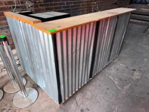 DESCRIPTION 60" L SHAPED WOODEN BAR WITH CORRUGATED METAL FRONT. LOCATION OUTSIDE QTY 1