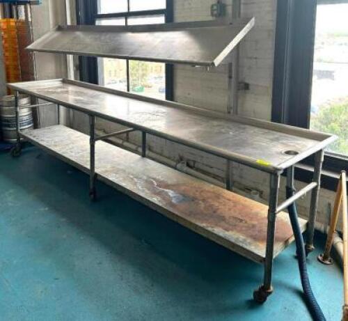 DESCRIPTION: 12' STAINLESS STEEL TABLE WITH RISER AND UNDERSHELF ON CASTERS SIZE: 144"X36"X36" LOCATION: KITCHEN QTY: 1